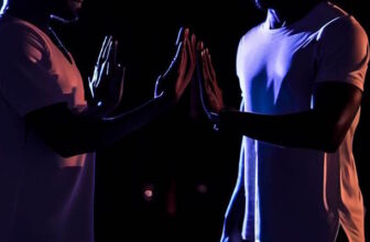 two men standing near each other at night, attempting to shield themselves