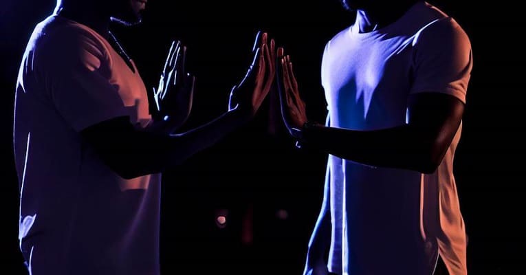 two men standing near each other at night, attempting to shield themselves